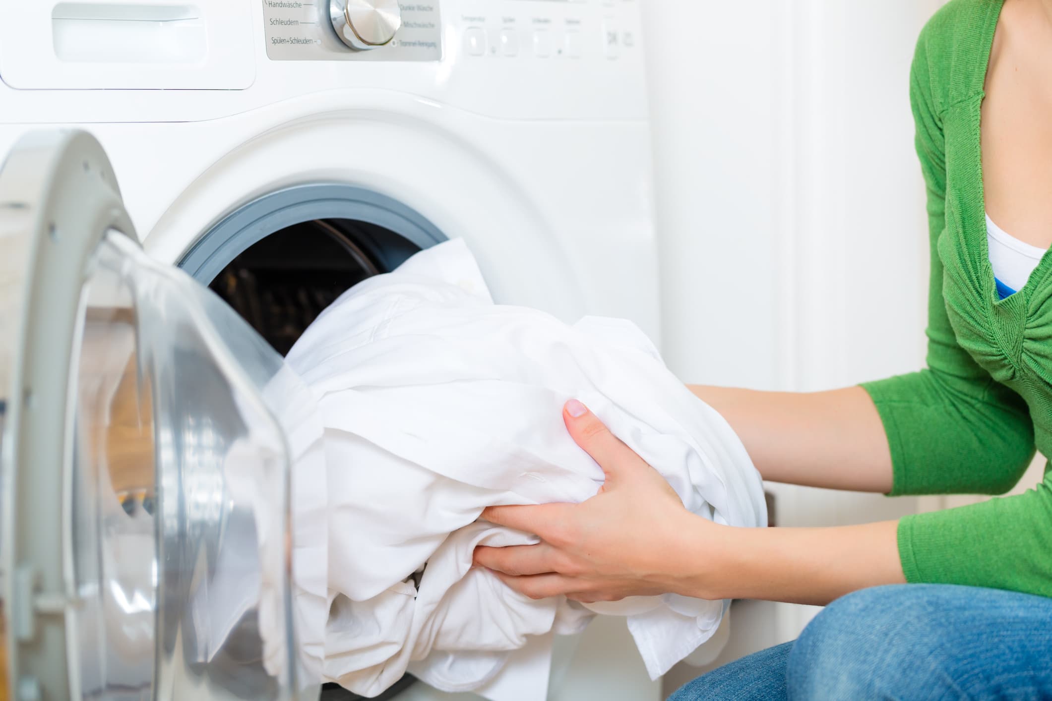 Person putting laundry into washing machine